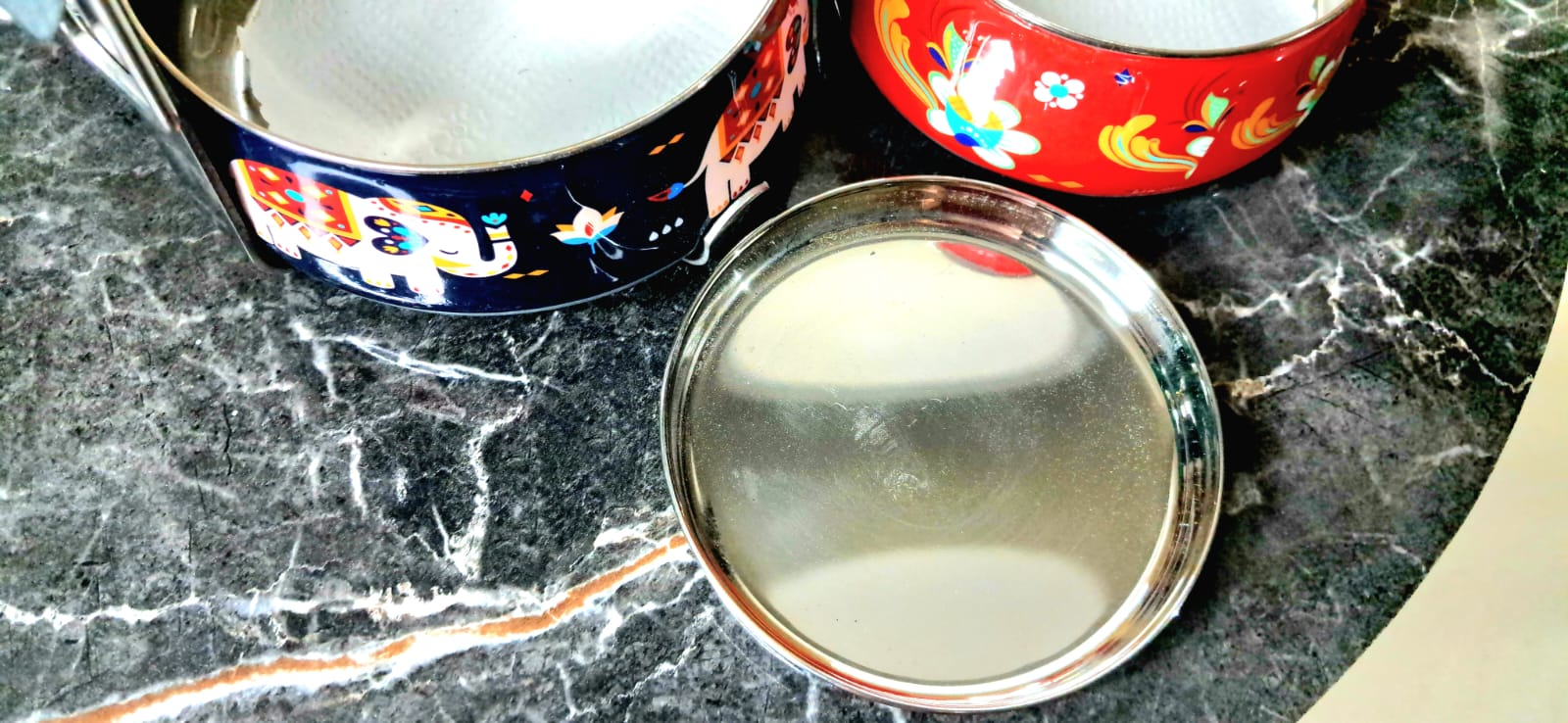 Metallic container lids on a marble surface